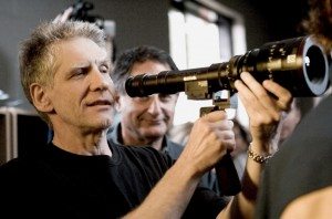A man is holding a camera and looking at it.