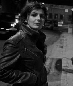 A black and white photo of a woman in a leather jacket.