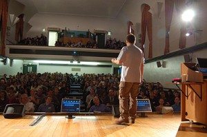 A man standing on stage in front of an audience.